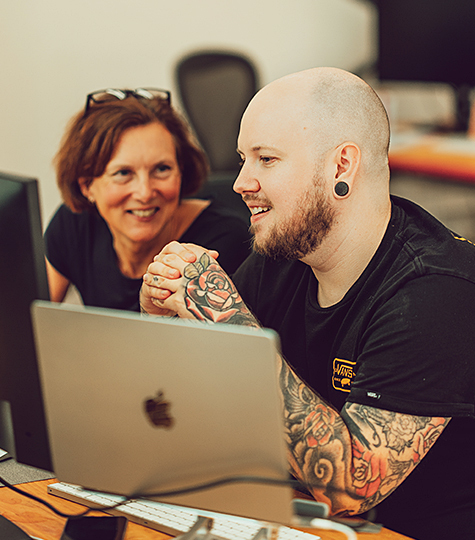 A project manager and web developer chatting about a client digital project, in the Birmingham agency's studio space