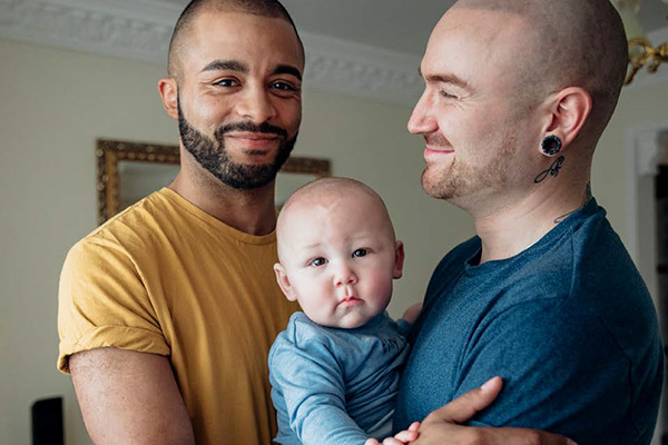 A gay couple holding their baby