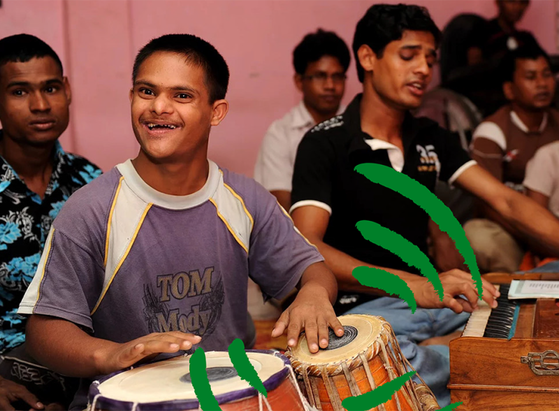 A young L'Arche member plays bongos