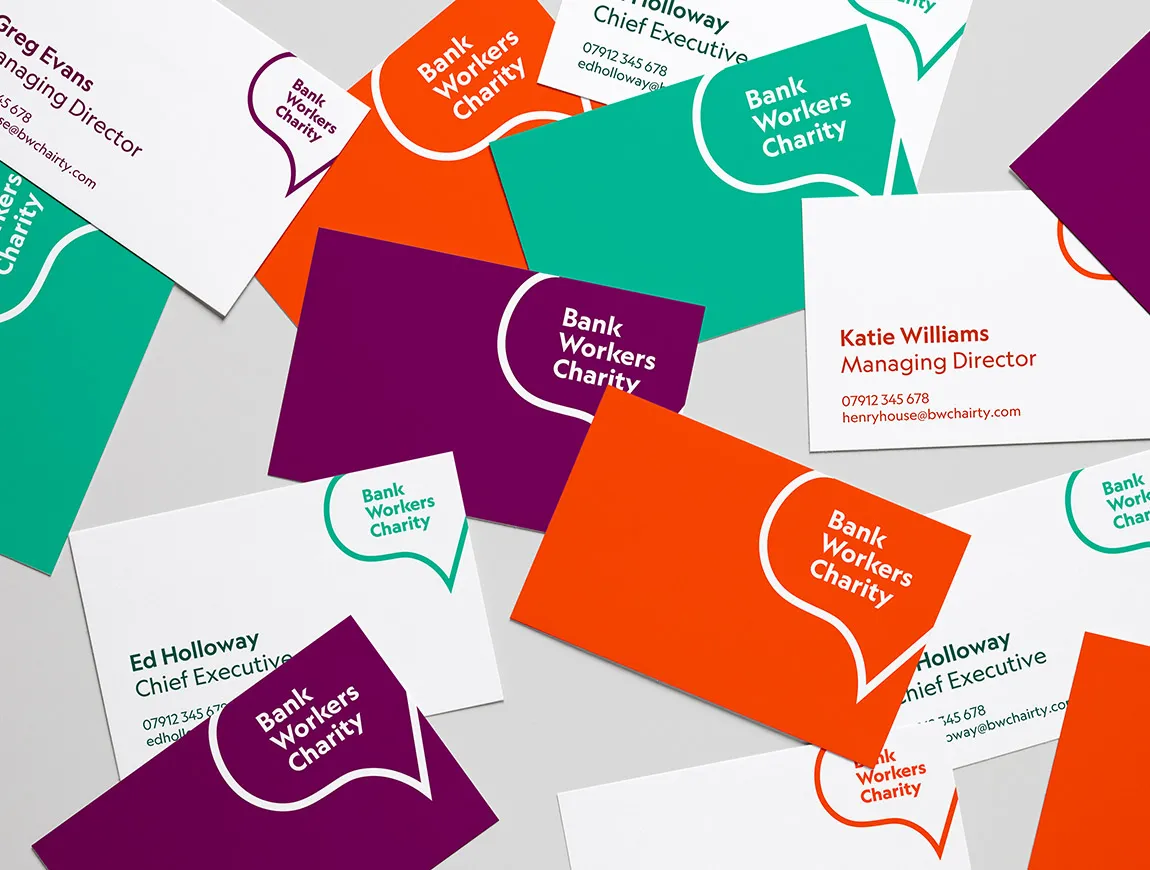 A jumbled pile of Bank Workers Charity business cards in green, orange and purple. 